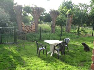 a table and chairs in a field with trees at Logement entier jardin clos parc chien A1 A29 5 mn in Herleville