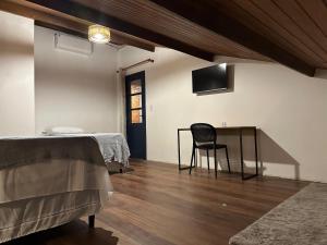 a bedroom with a bed and a desk with a chair at Bangalô Hospedagens in São Luís