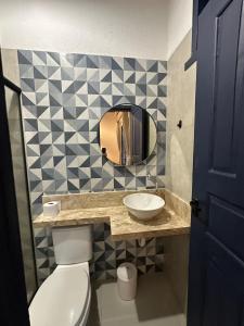 a bathroom with a toilet and a sink and a mirror at Bangalô Hospedagens in São Luís