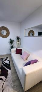 a white couch in a living room with pillows on it at See Love 2 in Zagreb