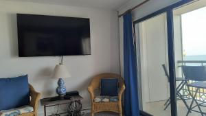 a living room with two chairs and a flat screen tv at Edgewater House in Rehoboth Beach