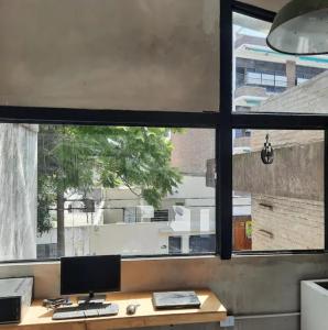 a desk with a computer on it in front of a window at LodelaAbuela 2 in Ciudadela