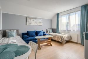 a living room with a blue couch and a chair at Domki letniskowe i pokoje u Katarzyny in Ustronie Morskie