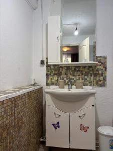 a bathroom with a sink and a mirror with butterflies on it at Casa Dorina 2 in Techirghiol