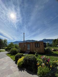 a small wooden cabin with a garden at Lovingly renovated 120-year-old train car! in Ramsau am Dachstein