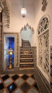 a staircase in a building with a chandelier at Riad Arous Chamel in Tangier