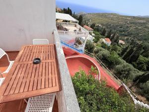 a balcony with a wooden table and a slide at Art & Motion Union - Guest Room 2 in Apoíkia