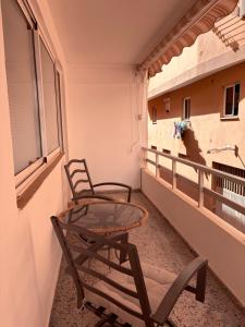 two chairs and a glass table on a balcony at Casa Lana - Cozy Beachside Studio in Puertito de Güímar