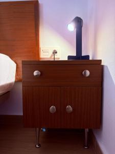 a lamp on top of a wooden dresser in a bedroom at Casa Lana - Cozy Beachside Studio in Puertito de Güímar