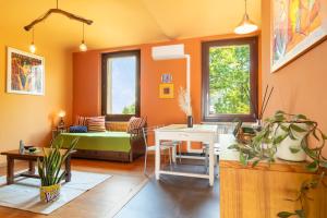 a living room with orange walls and a table and a couch at Aurorina, appartamento con giardino in Torre Pellice