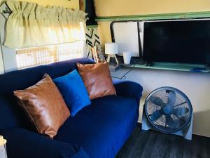 a living room with a blue couch and a fan at Tim Vales place in Tampa
