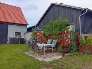 a table and chairs in a yard next to a building at Ferienhäuschen Berg und Tal in Harzgerode