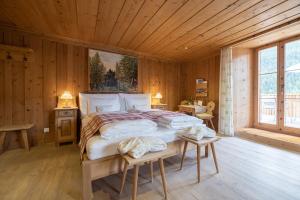 a bedroom with a large bed in a wooden room at Relais & Châteaux IN LAIN Hotel Cadonau in Brail