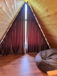 a bedroom with a red curtain in a cabin at Chachkari Cottage in Gogasheni