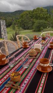 a table with plates and bowls on top at Willkay Glamping in Tafí Viejo