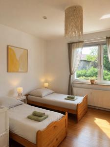 two beds in a room with a window at Gemütliche Ferienwohnungen Teterow für bis zu 10 Personen in Teterow
