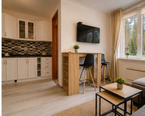 a living room with a kitchen with a table and chairs at Apartmani Krčmarica 10 in Divčibare