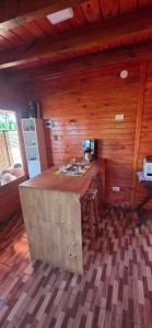 a kitchen with a counter in a wooden cabin at Encantos del Monte in Gobernador Roca