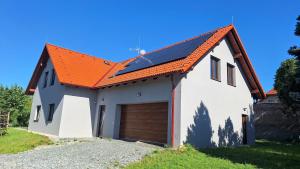 a white house with an orange roof with a garage at Thomas home in Homole