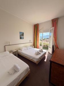 a hotel room with two beds and a window at Hotel Madame Mere in Saint-Florent +51 photos