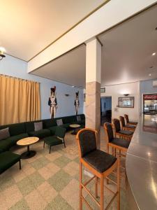 a waiting room with a green couch and chairs at Hotel Madame Mere in Saint-Florent