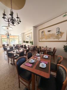 a dining room with tables and chairs and a chandelier at Hotel Madame Mere in Saint-Florent