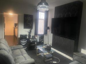 a living room with a couch and a flat screen tv at Wolverhampton Room in Wolverhampton