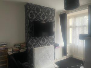 a living room with a flat screen tv on a wall at Wolverhampton Room in Wolverhampton