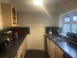 a kitchen with a sink and a white door at Wolverhampton Room in Wolverhampton