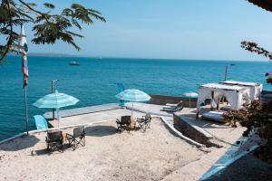 ein Strand mit Liegestühlen und Sonnenschirmen und das Meer in der Unterkunft Hotel Isla Real in Tierra Bomba