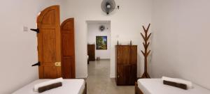 a room with two beds and a wooden door at Moksha Villa-Hostel Kandy in Kandy +91 photos