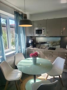 a kitchen with a table and white chairs and a kitchen at Ferienwohnung Südterrasse mit Kamin Bj 2019 in Timmendorfer Strand