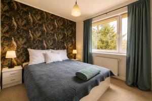 a bedroom with a bed and a large window at Apartamenty na Fali in Mrzeżyno