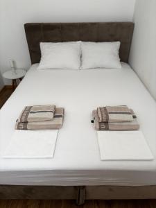 a bed with two towels on top of it at Apartman AN12 in Neum