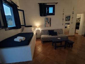 a living room with a bed and a couch at ENDLESS BLUE Milos in Provatas