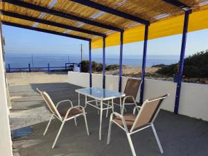a table and chairs on a patio with a view of the ocean at ENDLESS BLUE Milos in Provatas