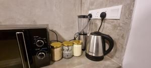 a kitchen counter with a blender and five jars at Moksha Villa-Hostel Kandy in Kandy