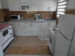 a kitchen with white appliances and a white refrigerator at Apartman Dzans in Jajce +5 photos