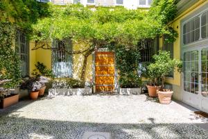 a courtyard with a door and trees and plants at Duomo Smart Suites in Milan