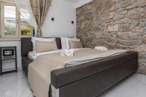 a bedroom with a large bed and a stone wall at Villa Vita luxury Apartments in Crikvenica +230 photos