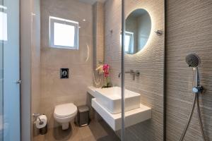 a bathroom with a sink and a toilet and a mirror at Gelli Apartments in Kos +50 photos