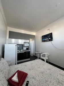 a small room with a bed and a kitchen at Palmares Hotel in Palmares do Sul