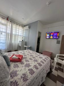 a bedroom with a bed and a tv on the wall at Palmares Hotel in Palmares do Sul