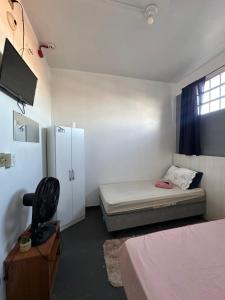 a small room with a bed and a refrigerator at Palmares Hotel in Palmares do Sul