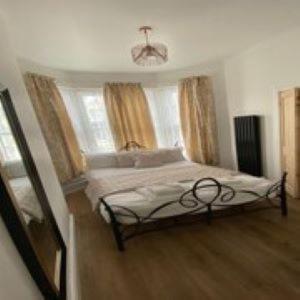 a bedroom with a bed in a room with windows at Alexander's luxury rooms all en-suite, spa bath in Blackpool