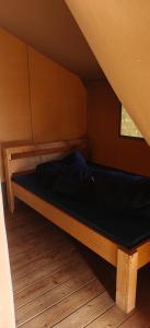 a wooden bed in a room with a window at Camping Amable in Someren