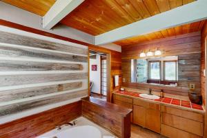 a bathroom with wooden walls and a tub and a sink at RiverPoint Retreat in Sandpoint +75 photos