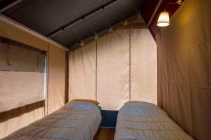 a small bedroom with two beds in it at Camping De Kooiplaats in Schiermonnikoog