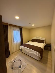a bedroom with a large bed and a window at Erkonak Pansiyon in Uzungöl