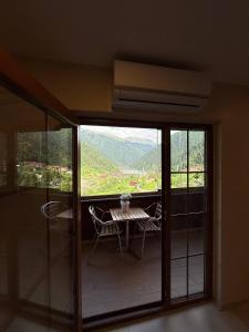 a room with a table and chairs on a balcony at Erkonak Pansiyon in Uzungöl